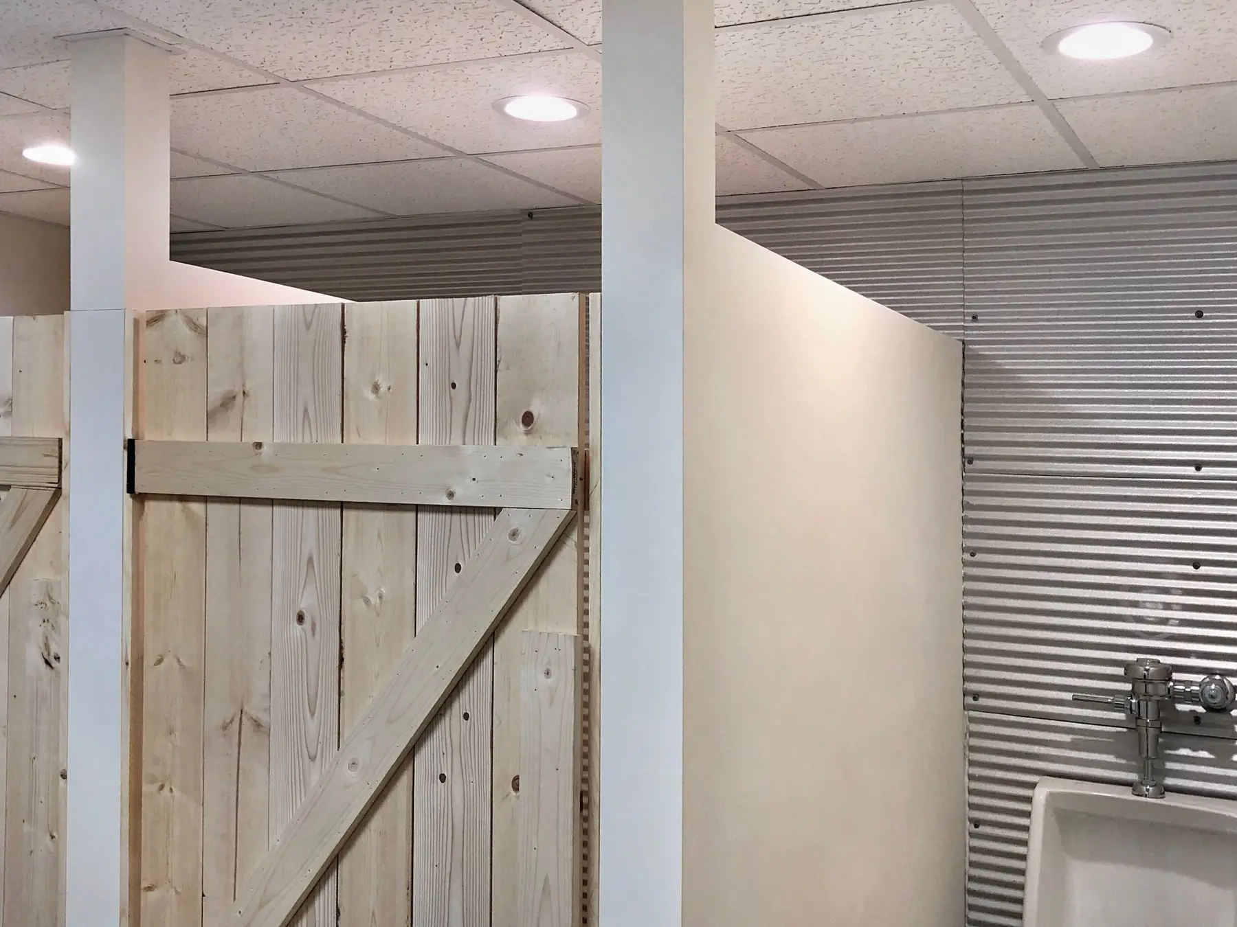 Finished basement with recessed lights, shiplap wall and a sliding barn door.