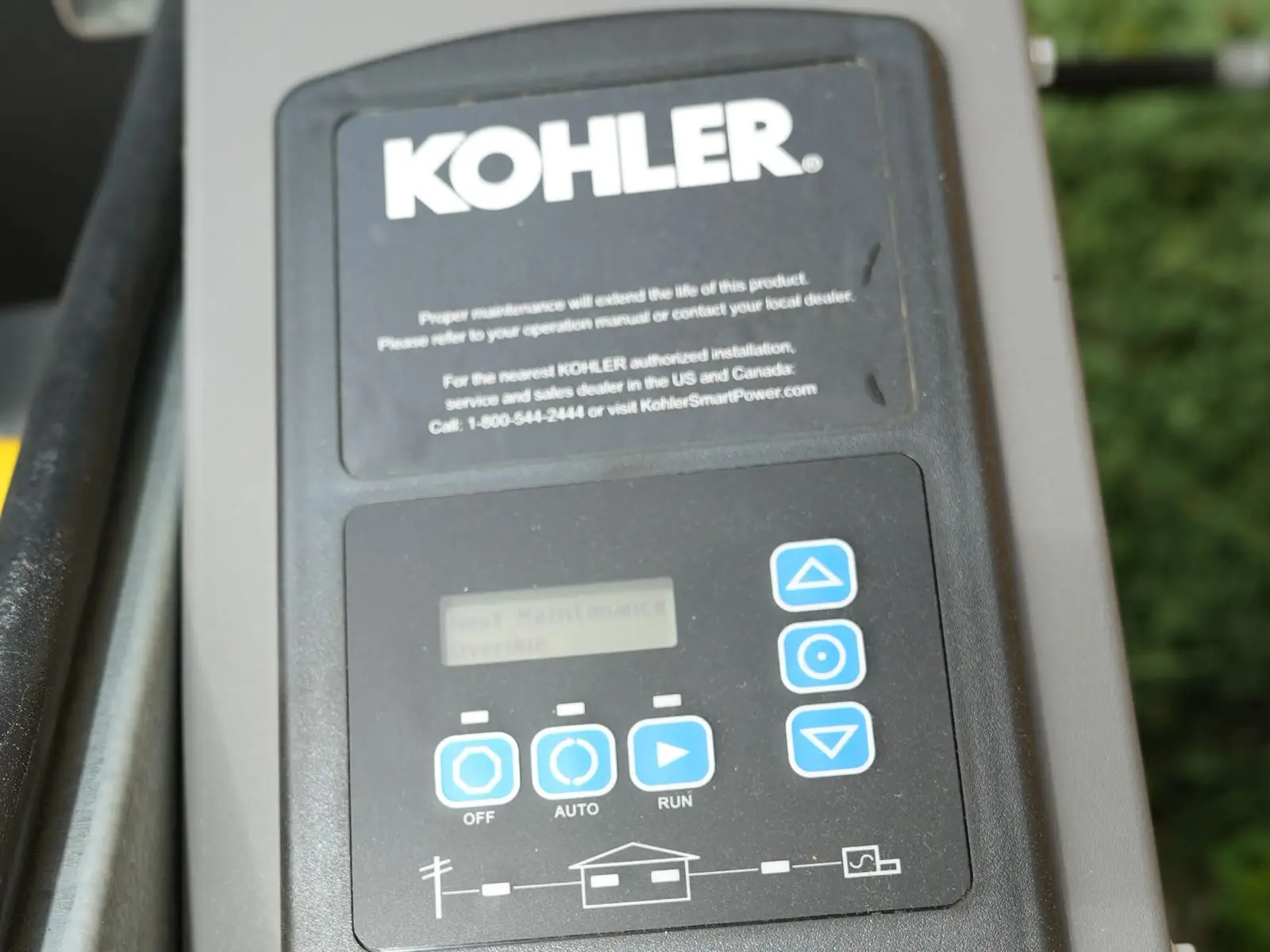 Close-up of the Kohler logo and digital controller on an installed standby generator.