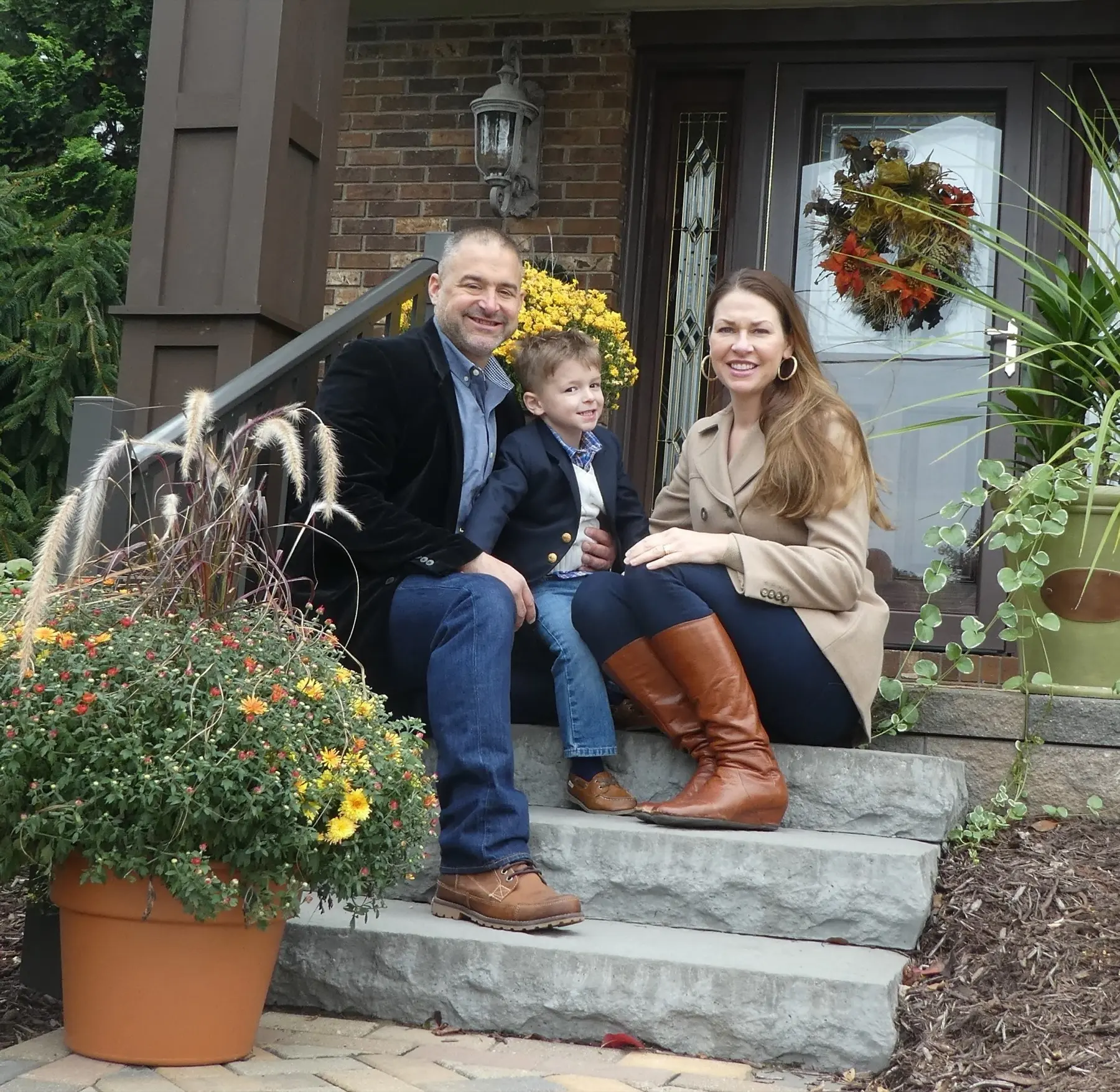David, Darla and Dylan Osaba sitting together on the front steps of their home.