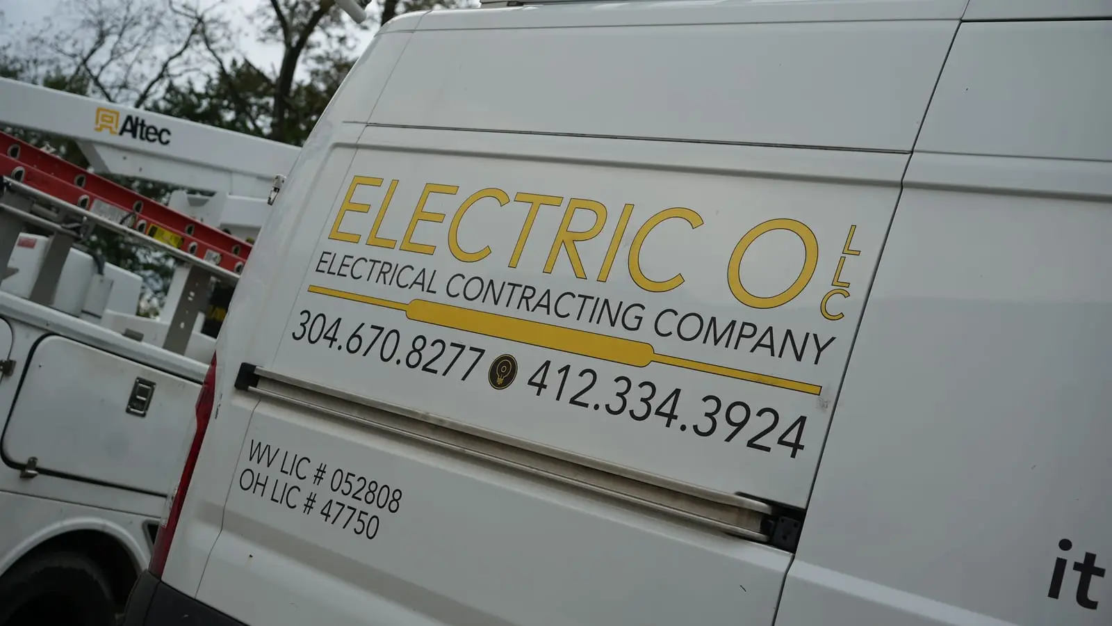 Close-up of the Electric O lettering on a van: the logo, both phone numbers and the West Virginia and Ohio license numbers.